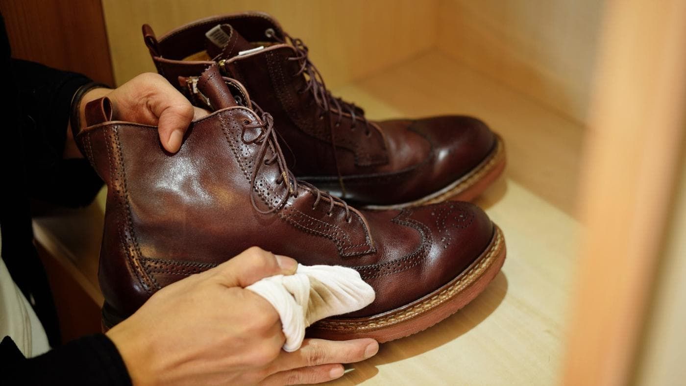 hands cleaning brown shoes