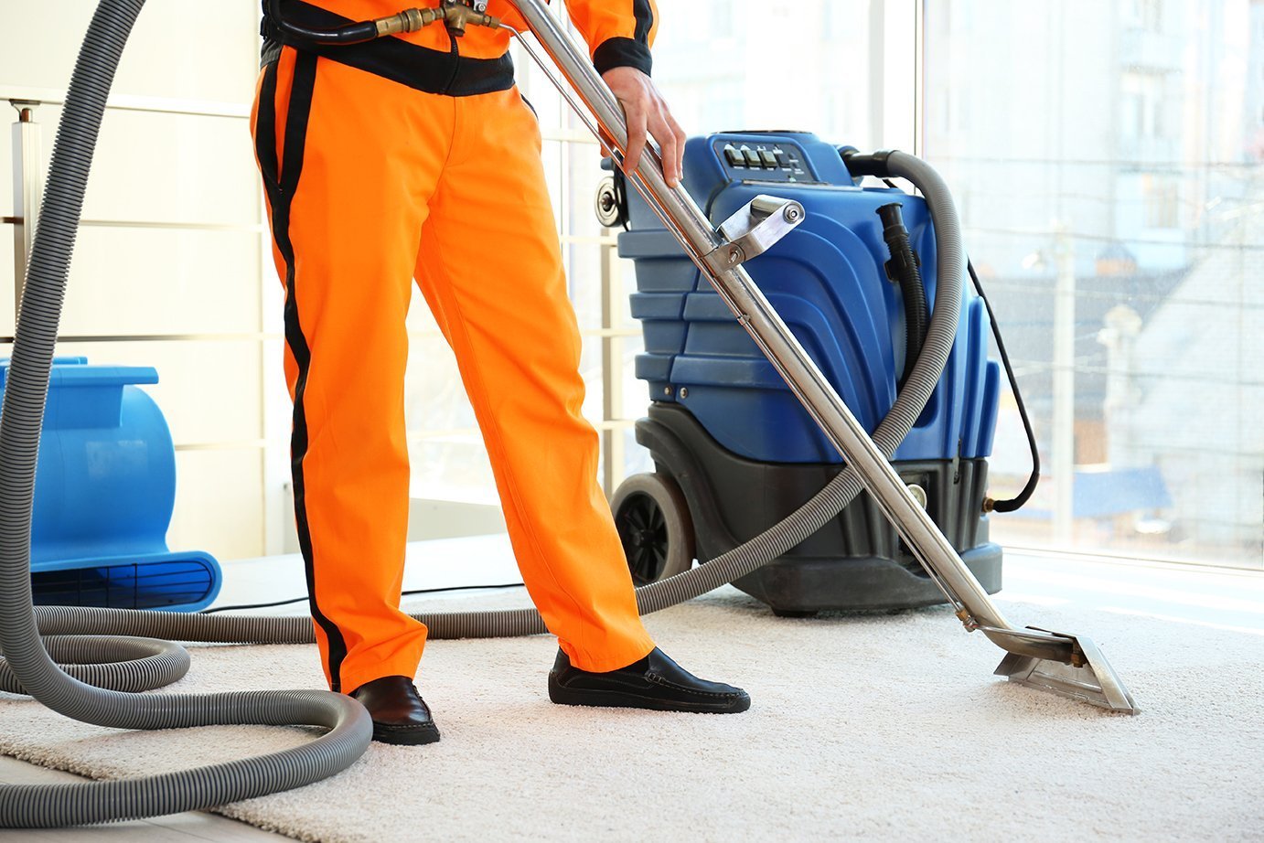 a laundry worker cleaning carpet with vaccum cleaner