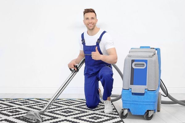 man doing thumbs up while cleaning carpet
