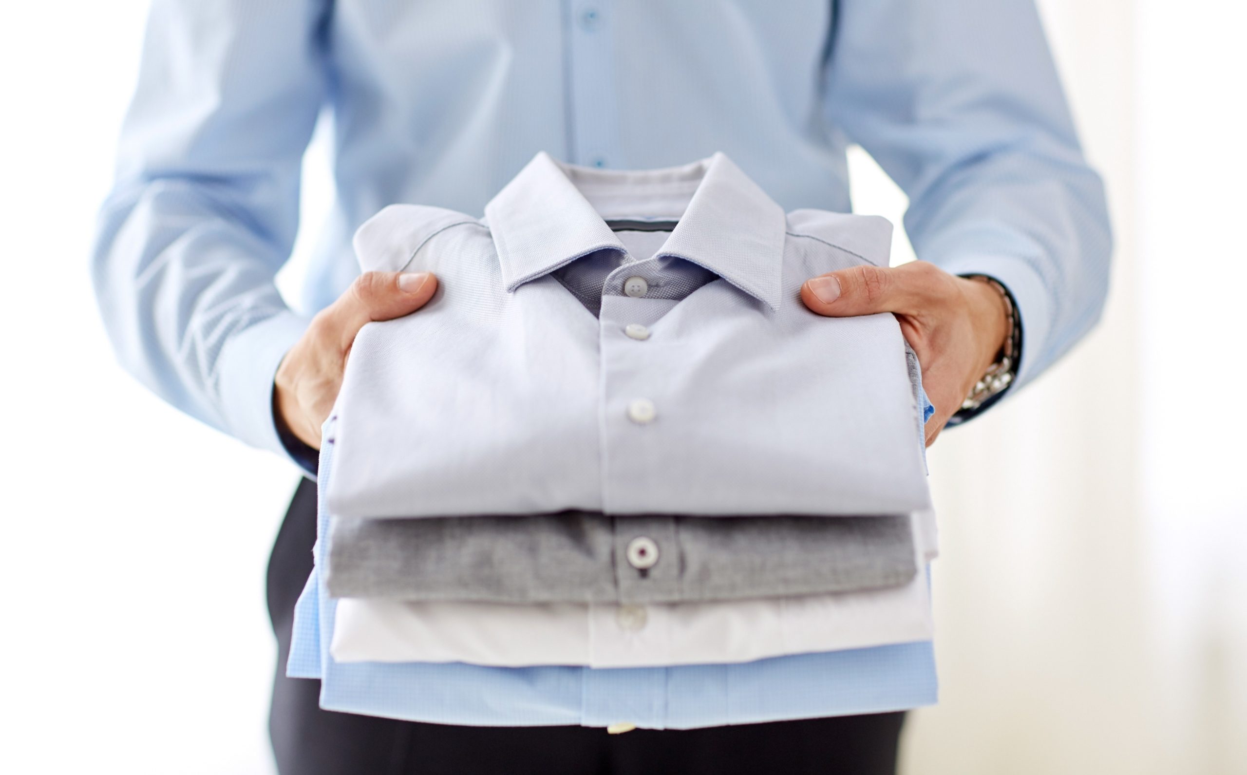 man holding folded clothes