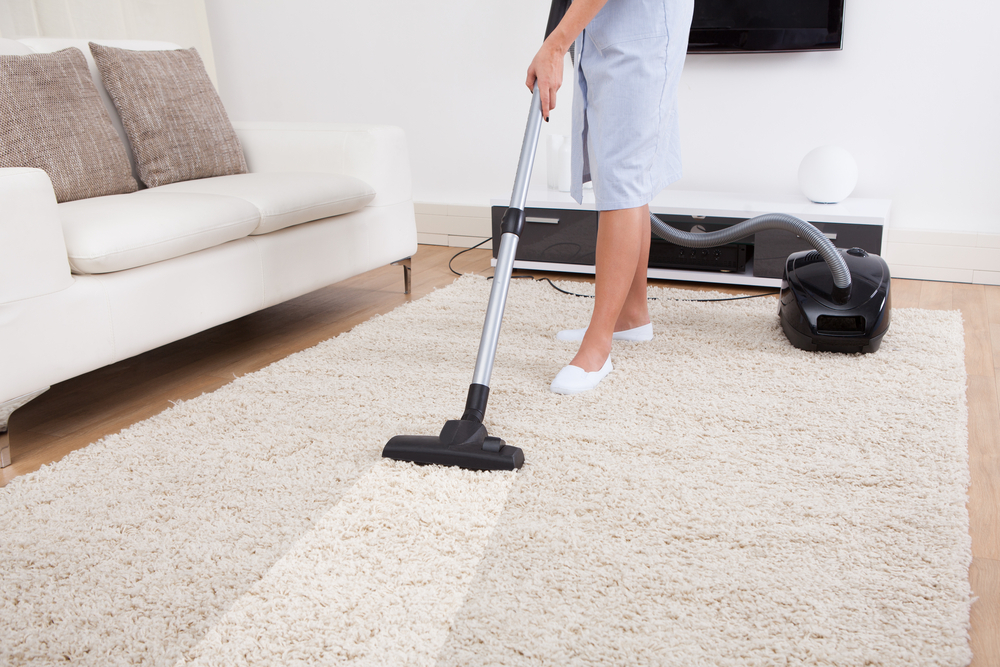 A lady is cleaning the carpet