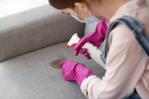 Expert girl is cleaning the sofa