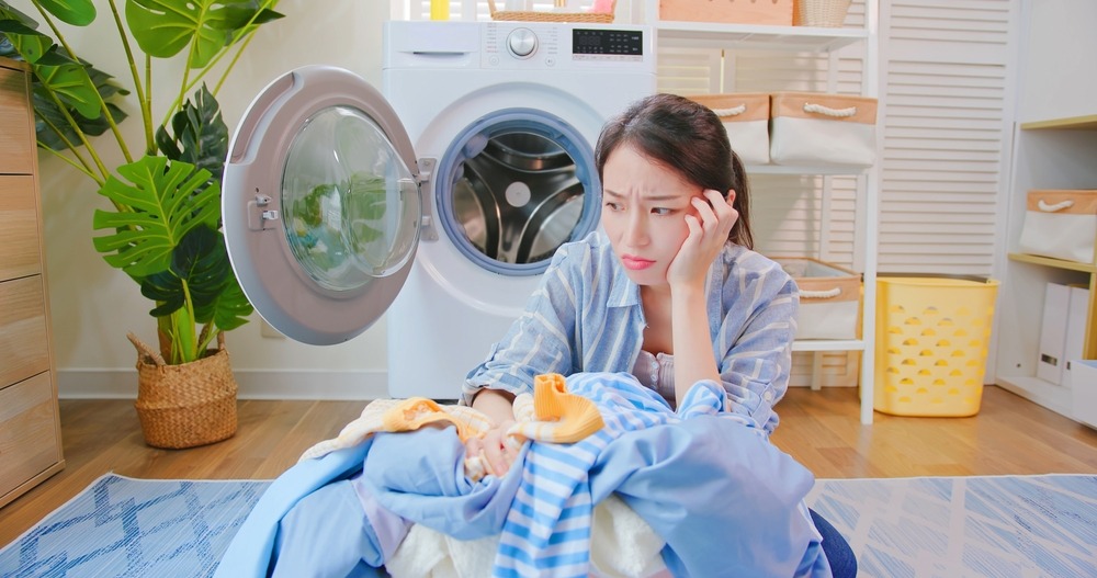 woman sadly sittting with unwashed clothes
